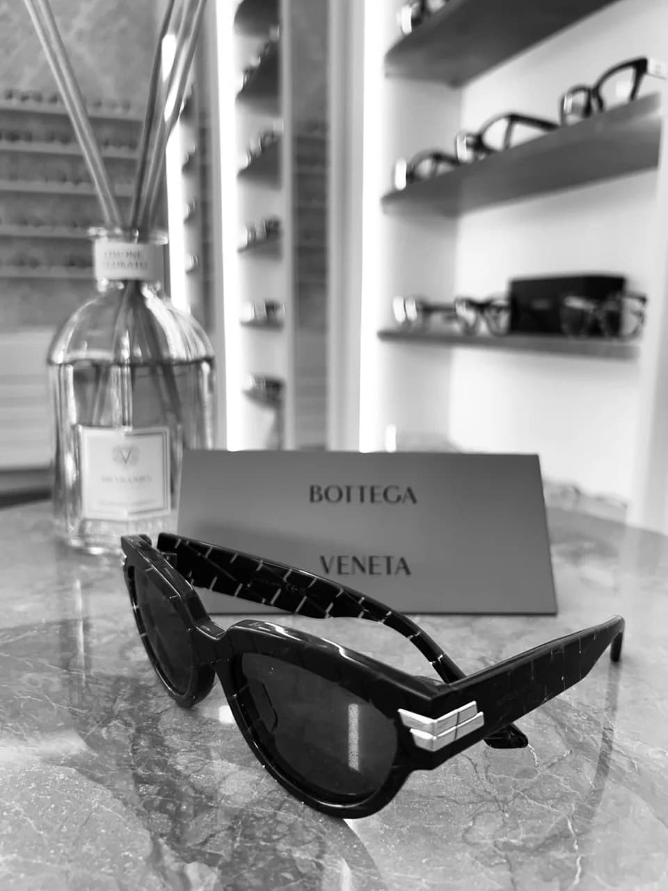 Occhiali da sole sul banco della boutique, fotografati in bianco e nero